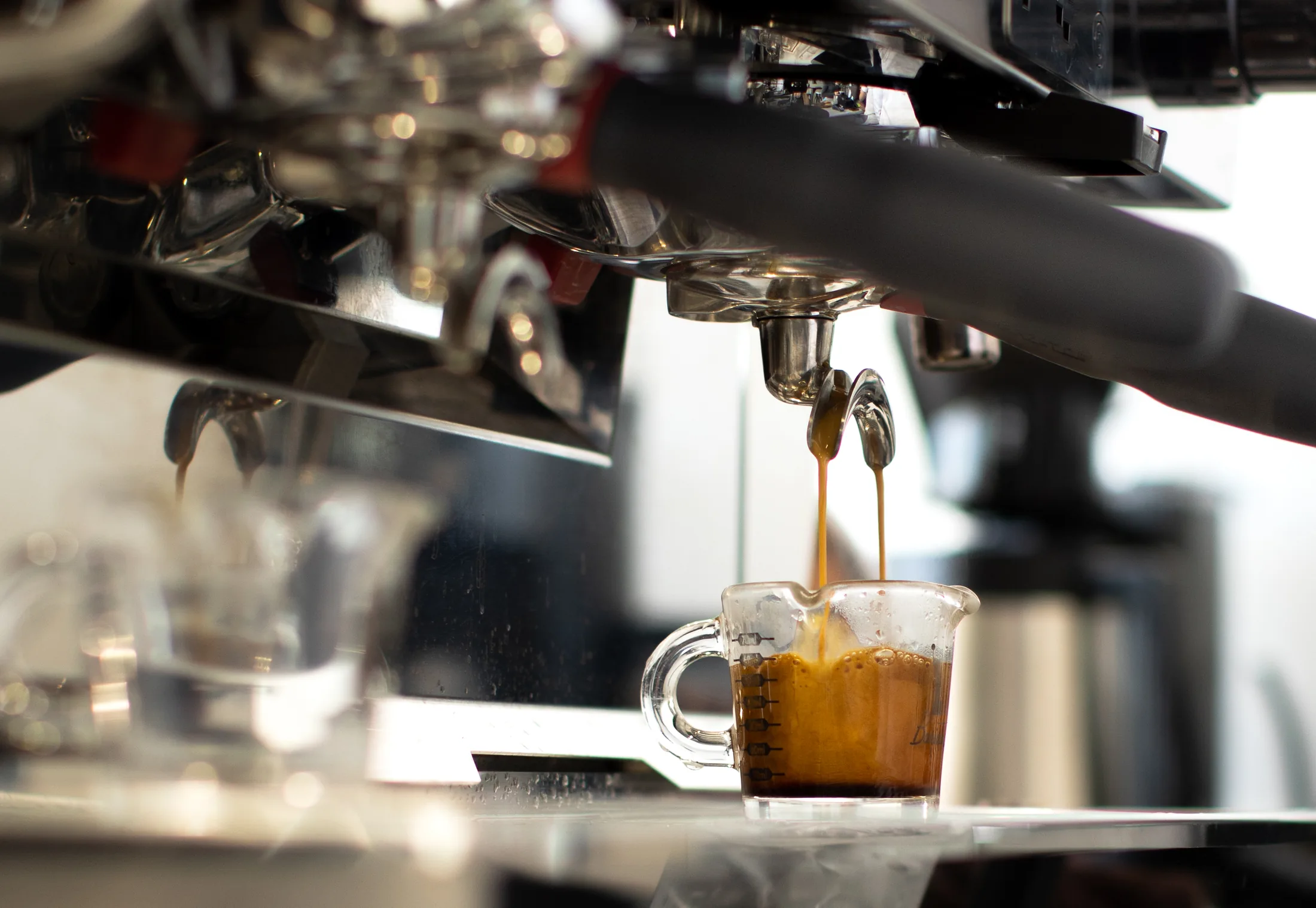 Shot de espresso saliendo de la máquina en la barra de Vertical Coffee